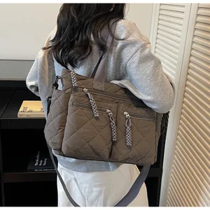 Side view of woman wearing dark brown quilted nylon crossbody bag with wide shoulder strap