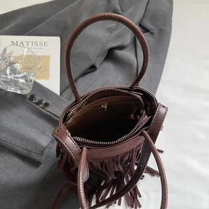 Sac seau marron foncé à franges avec poignées rondes et bandoulière en scène de vie