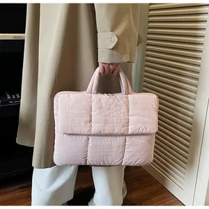Detailed view of pale pink quilted tote bag with padded handles and puffer texture