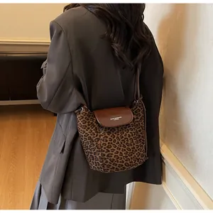 Close-up of leopard print bucket bag with brown leather flap and stylish brand logo