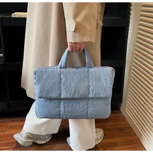 Dettaglio di una borsa tote trapuntata celeste con imbottitura morbida e manici corti