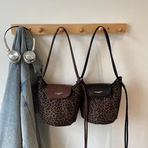 Trend Leopard print bucket bags with leather flaps and shoulder straps hanging on wall
