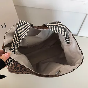 Leopard print tote bag with spacious interior and checkerboard woven shoulder strap