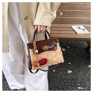 Detail of plush heart-patterned panel and gold twist lock on stylish handbag