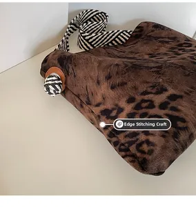 Detailed close-up of leopard print canvas bag featuring decorative side knots and crimping process