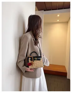 Detail of plush heart-patterned bag with gold swivel lock and leather shoulder strap