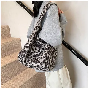 Detail view of large leopard print plush tote bag showing soft faux fur texture and wide strap
