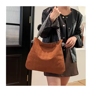 Detail of a brown woven hobo bag featuring thick black and white striped rope shoulder straps