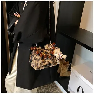Detail shot of leopard print plush crossbody bag with chain strap and beaded handle