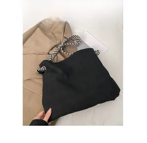Detail of black matte tote bag featuring unique black and white zebra woven rope straps