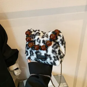 Chic faux fur leopard print handbag with large amber beaded handle and metal chain strap