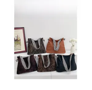 Detailed view of canvas tote bags in leopard prints and solid colors with striped handles