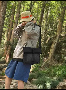 Detail view of nylon crossbody bag with buckle closure and checkered panel in forest setting