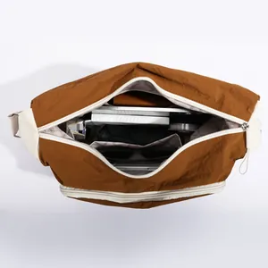 Caramel nylon crossbody bag with spacious interior showing tablet and daily essentials