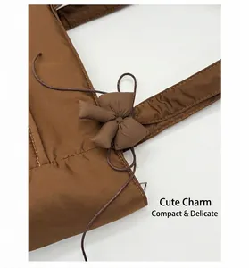 Detail of the quilted brown tote bag with a soft puffy texture and matching bow charm