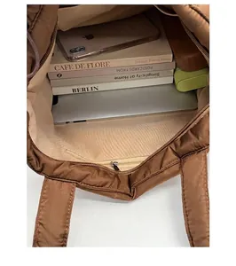Internal view of brown tote bag showing large capacity for laptop and zipper pocket