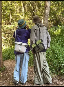 Outdoor crossbody messenger bag showing buckle closure and durable nylon mesh fabric