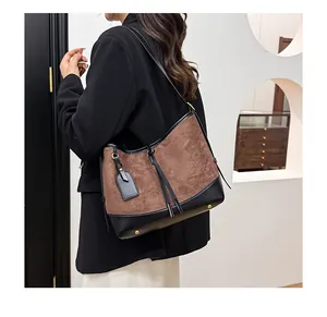 Détail du sac cabas en daim avec textures contrastées, cordon en cuir et boucles dorées