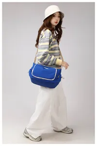 Detail of blue nylon crossbody bag featuring contrast trim and adjustable wide strap