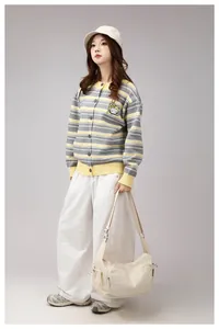 Detailed close-up of the cartoon embroidery and striped knit texture on the cardigan