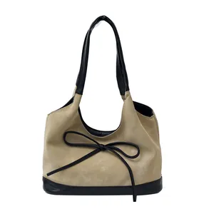 Retro khaki suede bucket bag with black bow detail and contrast shoulder strap