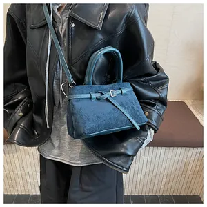 Detailansicht der dunkelblauen matten Wildleder-Eimertasche mit Lederband und Schnalle
