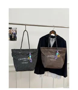 Detail of grid-pattern tote bags with rope handles and decorative star pendants