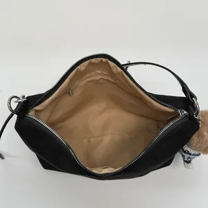 Minimalist black canvas crossbody bag interior with large capacity and zipped pocket