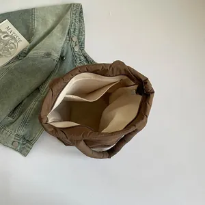 Large brown quilted nylon tote bag showing spacious interior with pockets for commuting