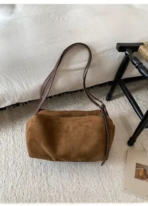 Macro shot of brown suede tote bag featuring premium matte texture and soft leather straps