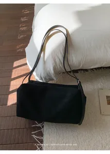 Detail of minimalist retro black tote bag with matte texture on white rug