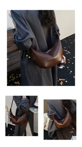 Macro view of dark brown crescent hobo bag with stitched seams and beaded charm detail