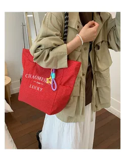 Detail of red checkered canvas tote bag with graphic print and star pendant accessory
