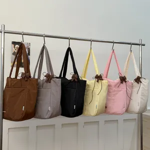 Minimalist quilted fabric tote bags for women in six colors with decorative bow detail