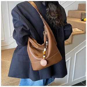 Vintage Hobo Tasche in Braun mit bunten Holzperlen Anhänger an der weiblichen Schulter
