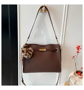 Detail of dark brown leather tote with gold twist lock and leopard print heart charm