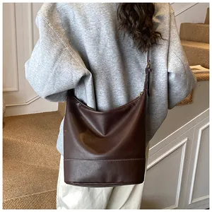 Detailansicht der dunkelbraunen Leder-Beuteltasche mit weißen Kontrastnähten für Damen