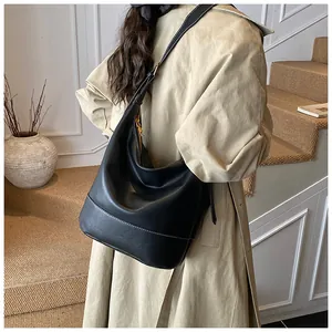 Detail einer schwarzen Hobo-Tasche mit weißen Kontrastnähten und goldenem Reißverschluss