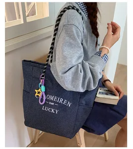 Detail view of large navy plaid tote bag with rope handles and star charms for women