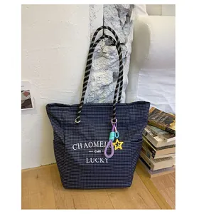 Detail of checkered canvas tote bag with thick rope handles and star pendant detail
