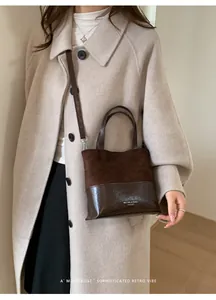 Detail of a brown leather bucket bag with mixed textures and Muting logo on a model