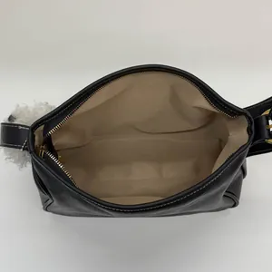 Sac sous le bras minimaliste en cuir noir avec surpiqûres blanches et zip doré élégant