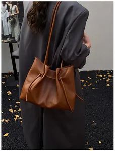 Close-up of caramel leather tote bag featuring elegant drawstring knot details