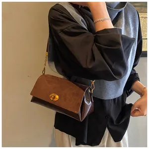 Détail du sac à bandoulière vintage avec rabat en daim et fermoir rotatif doré