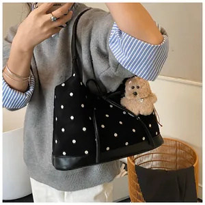 Close-up of black polka dot canvas tote bag featuring a bow and bear pendant