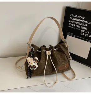 Detailed view of leopard print bucket bag with drawstring closure and plush cat charm