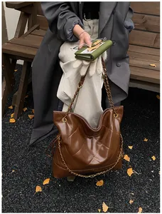 Close-up of dark brown quilted leather tote bag with elegant gold chain shoulder strap