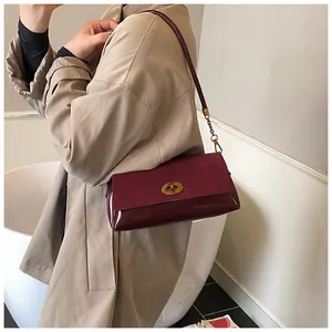 Détail du sac sous l'aisselle bordeaux avec patchwork en daim et fermoir doré