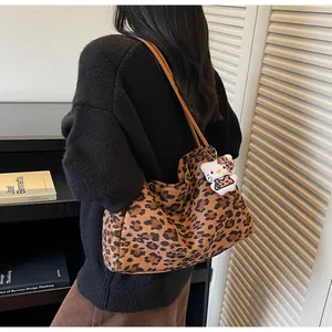 Vue détaillée du grand sac cabas imprimé léopard avec pendentif en peluche et anses