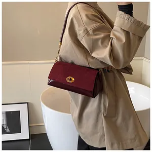 Détail du sac à bandoulière bordeaux avec patchwork en daim et fermoir doré chic